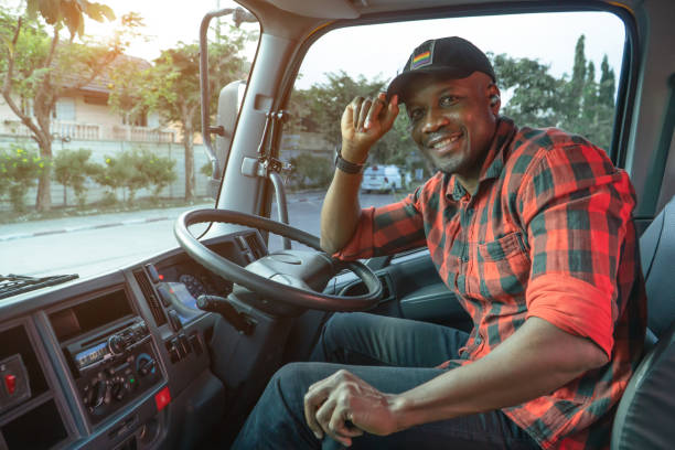 Smile Confidence Young Man Professional Truck Driver In Business Long transport. Portrait young man African American Trucking, Service, Transport and Delivery business owner driving happy at warehouse